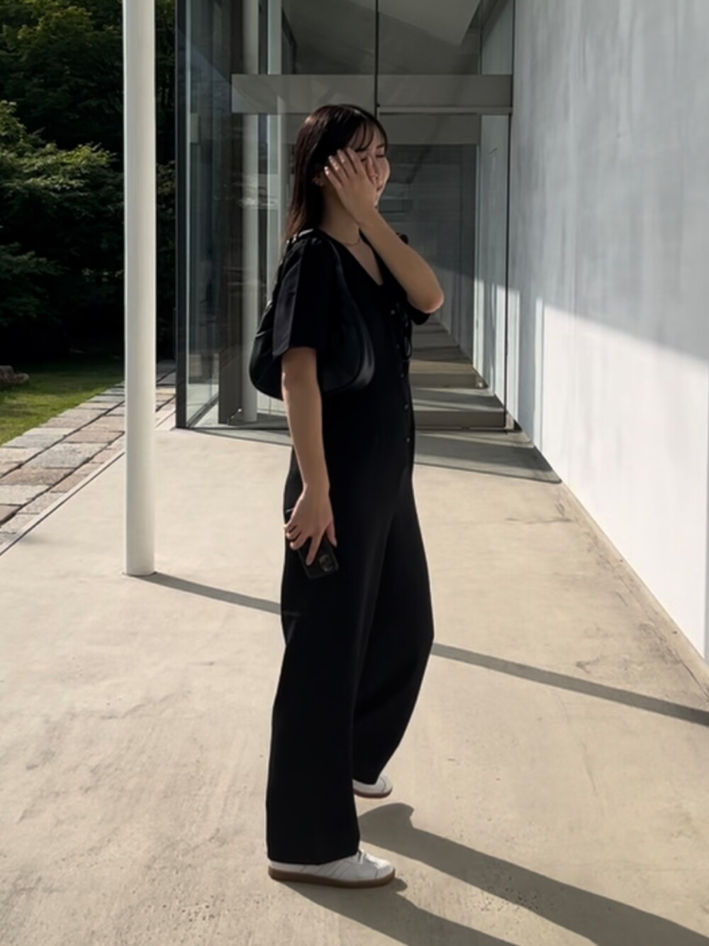 ブラック系のつなぎ/オールインワンを着用したレディースの夏コーディネートの2枚目の写真