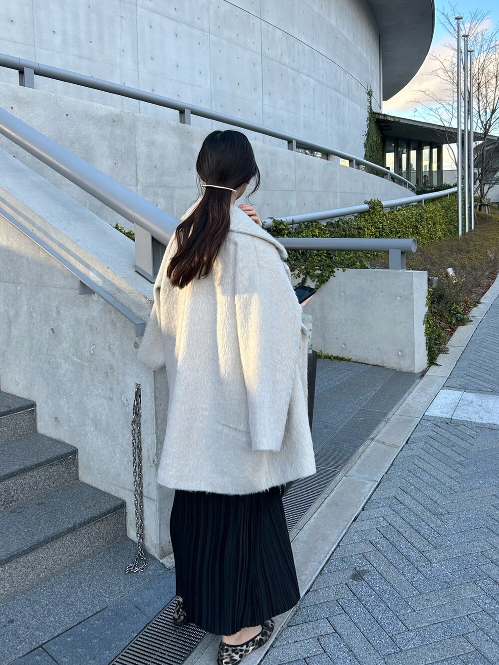 ブラック系のワンピース/ドレス、ホワイト系のジャケット/アウターを着用したレディースの春コーディネートの2枚目の写真