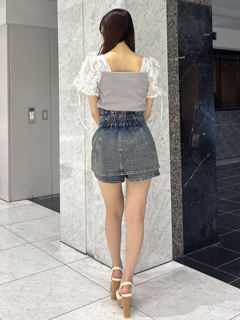 ブルー系のデニムパンツ、グレー系のTシャツ/カットソー、ホワイト系のサンダルを着用したレディースの春コーディネートの4枚目の写真