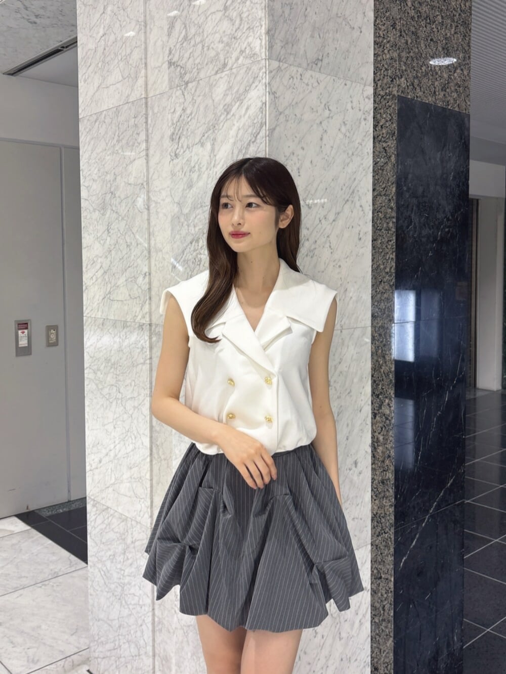 ブラック系のサンダル、グレー系のスカート、ホワイト系のTシャツ/カットソーを着用したレディースの夏コーディネートの5枚目の写真