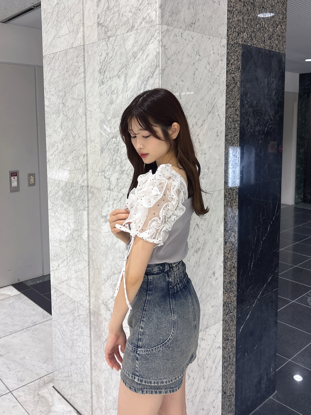 ブルー系のデニムパンツ、グレー系のTシャツ/カットソー、ホワイト系のサンダルを着用したレディースの春コーディネートの6枚目の写真