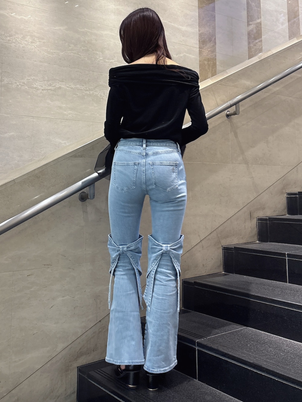 ブルー系のデニムパンツ、ブラック系のTシャツ/カットソー、ブラック系のサンダルを着用したレディースの冬コーディネートの4枚目の写真