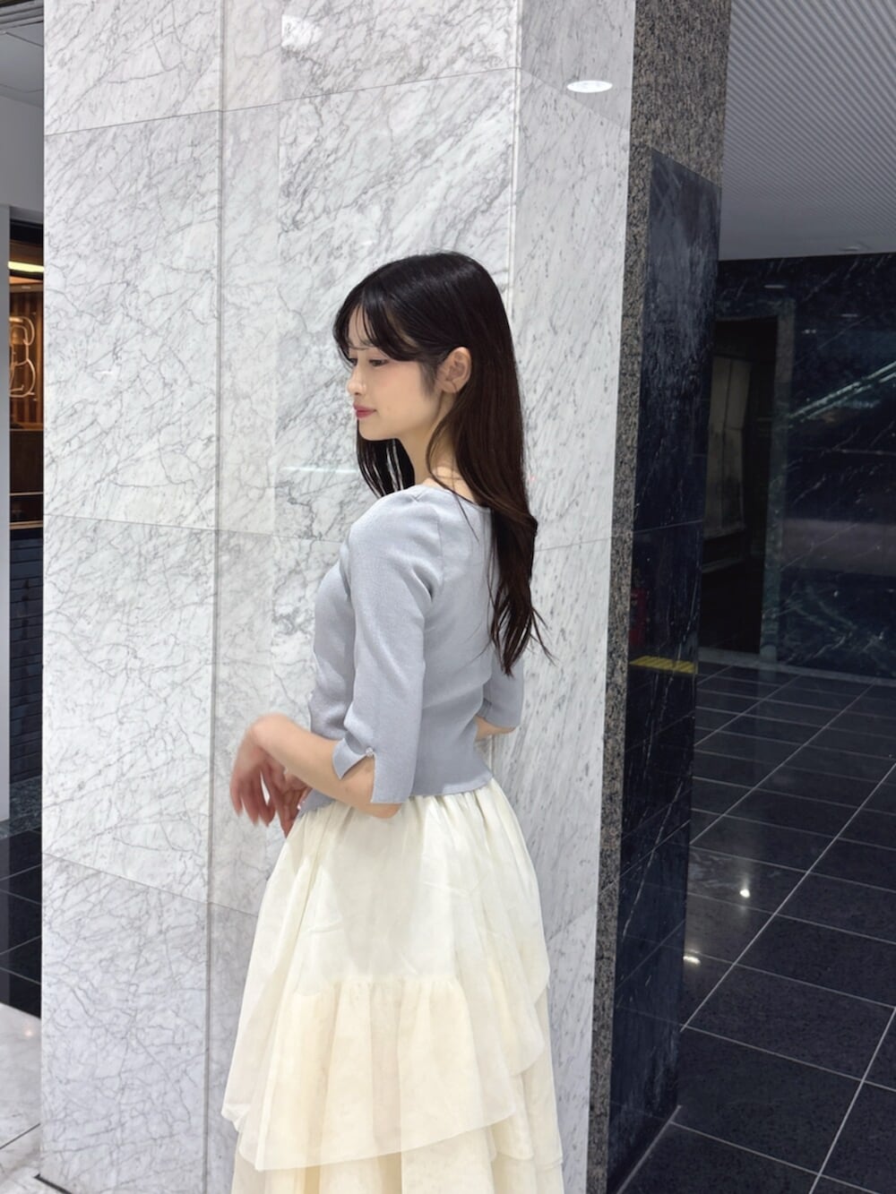 ホワイト系のスカート、グレー系のニット/セーター、ホワイト系のパンプスを着用したレディースの夏コーディネートの6枚目の写真