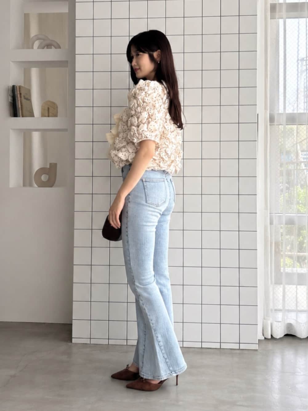 ブラウン系のハンドバッグ、ブルー系のデニムパンツ、ホワイト系のシャツ/ブラウスを着用したレディースの夏コーディネートの2枚目の写真