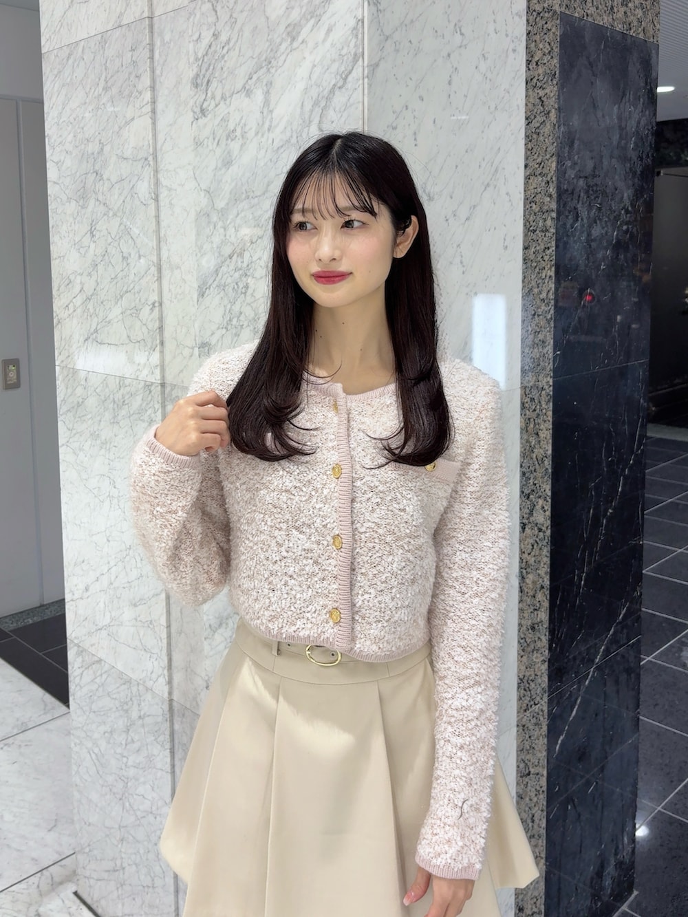 ホワイト系のスカート、ピンク系のノーカラージャケット、ブラウン系のブーツを着用したレディースの冬コーディネートの5枚目の写真