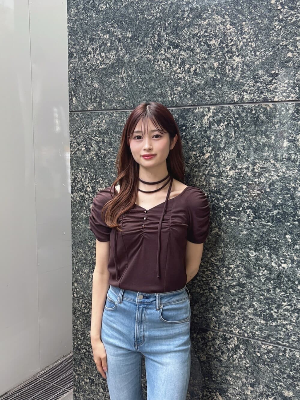 ブルー系のデニムパンツ、ブラウン系のTシャツ/カットソー、ブラウン系のサンダルを着用したレディースの春コーディネートの5枚目の写真