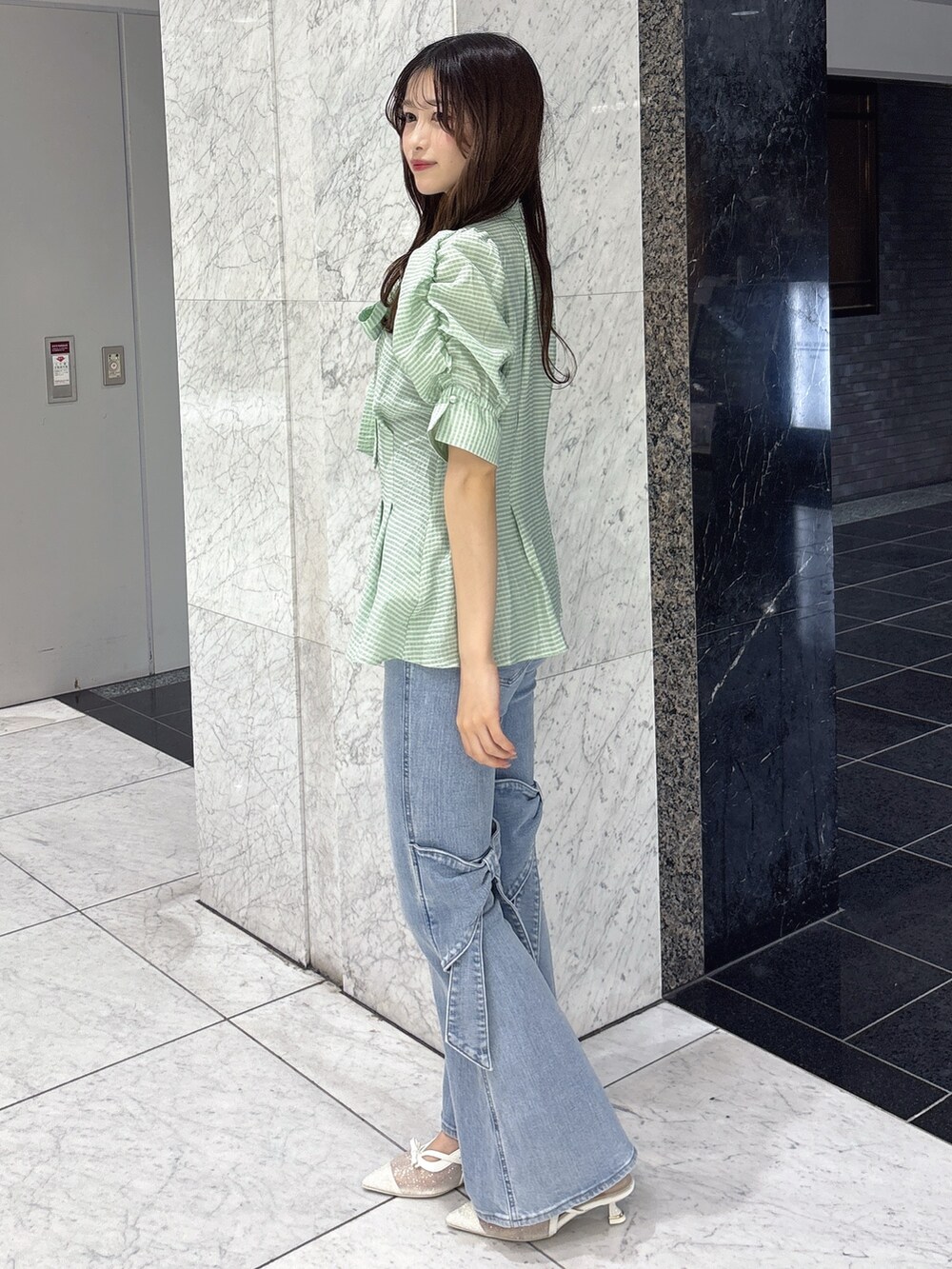 グリーン系のシャツ/ブラウス、ブルー系のデニムパンツ、ホワイト系のパンプスを着用したレディースの春コーディネートの2枚目の写真