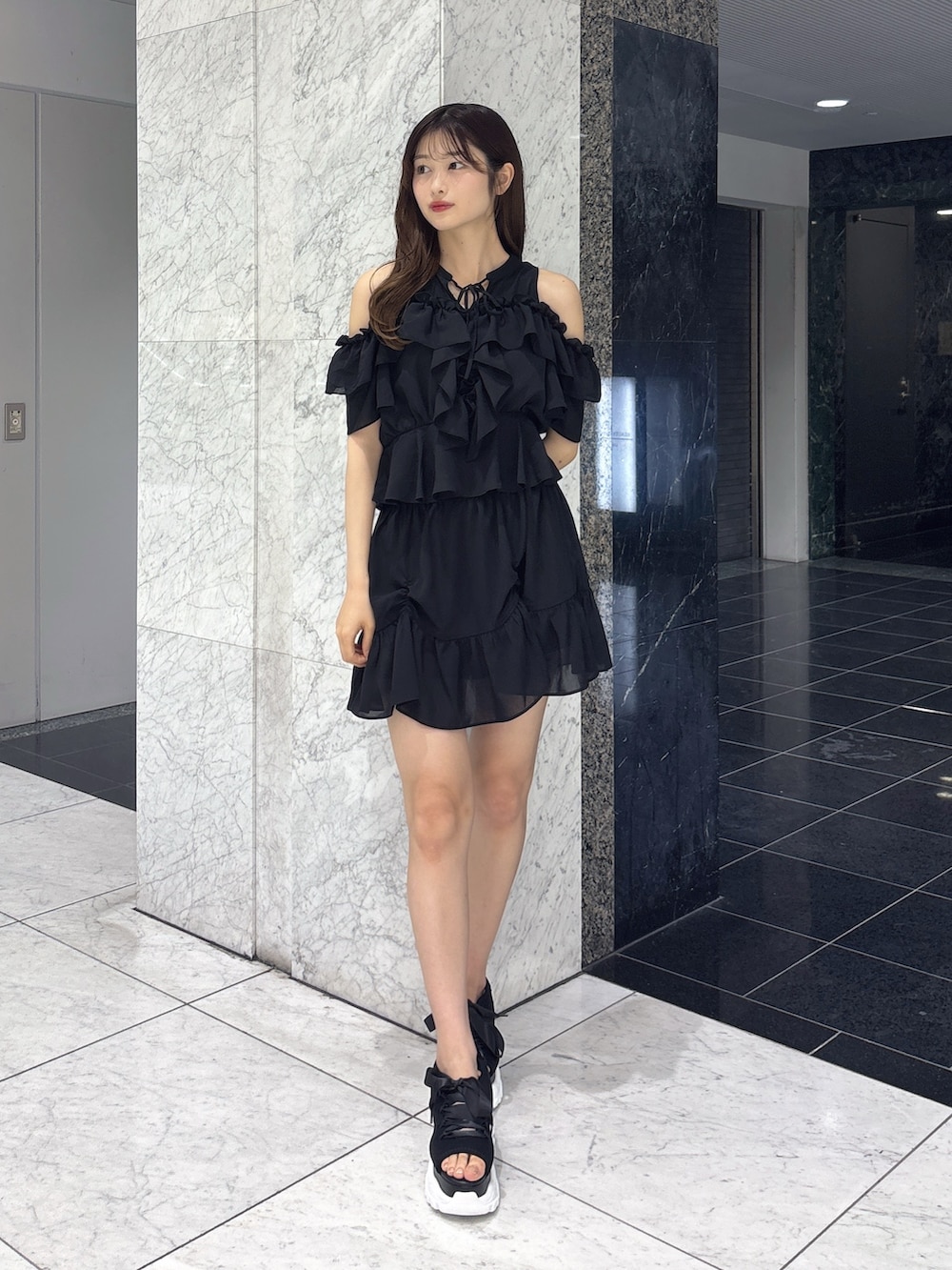 ブラック系のスカート、ブラック系のシャツ/ブラウス、ブラック系のサンダルを着用したレディースの春コーディネートの2枚目の写真