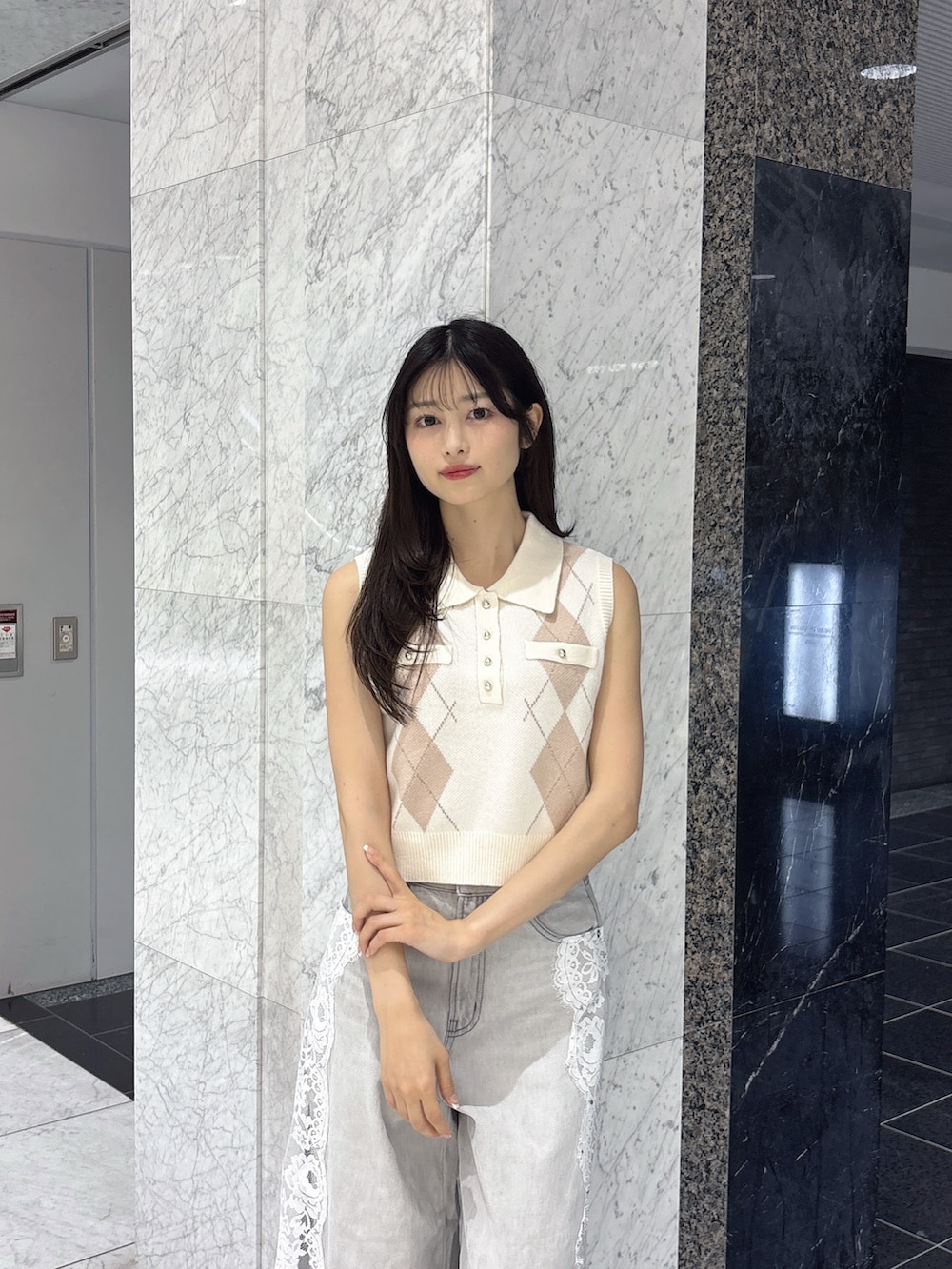 グレー系のデニムパンツ、ホワイト系のニット/セーター、ホワイト系のサンダルを着用したレディースの夏コーディネートの5枚目の写真