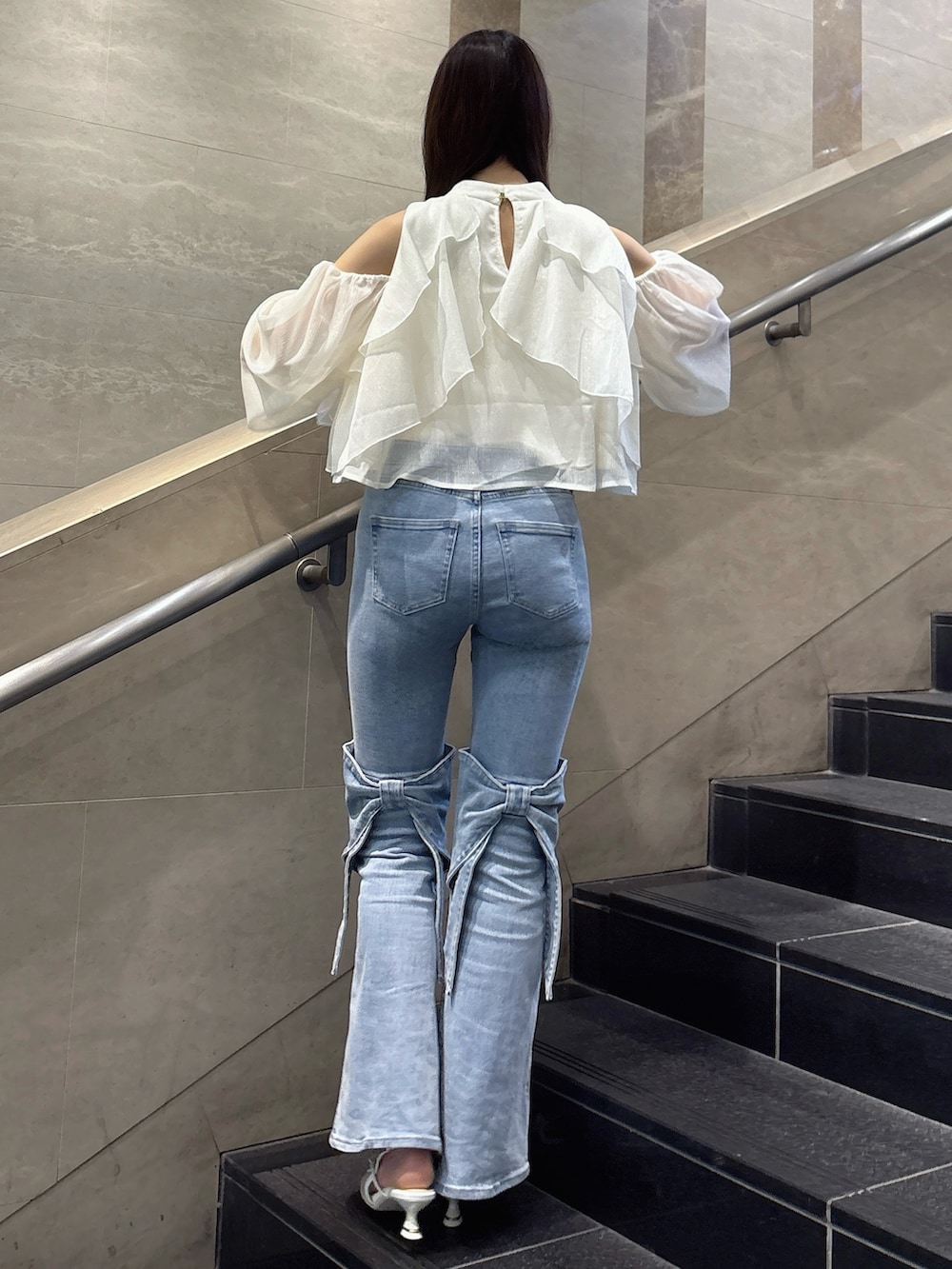 ブルー系のデニムパンツ、ホワイト系のシャツ/ブラウス、ホワイト系のパンプスを着用したレディースの春コーディネートの4枚目の写真