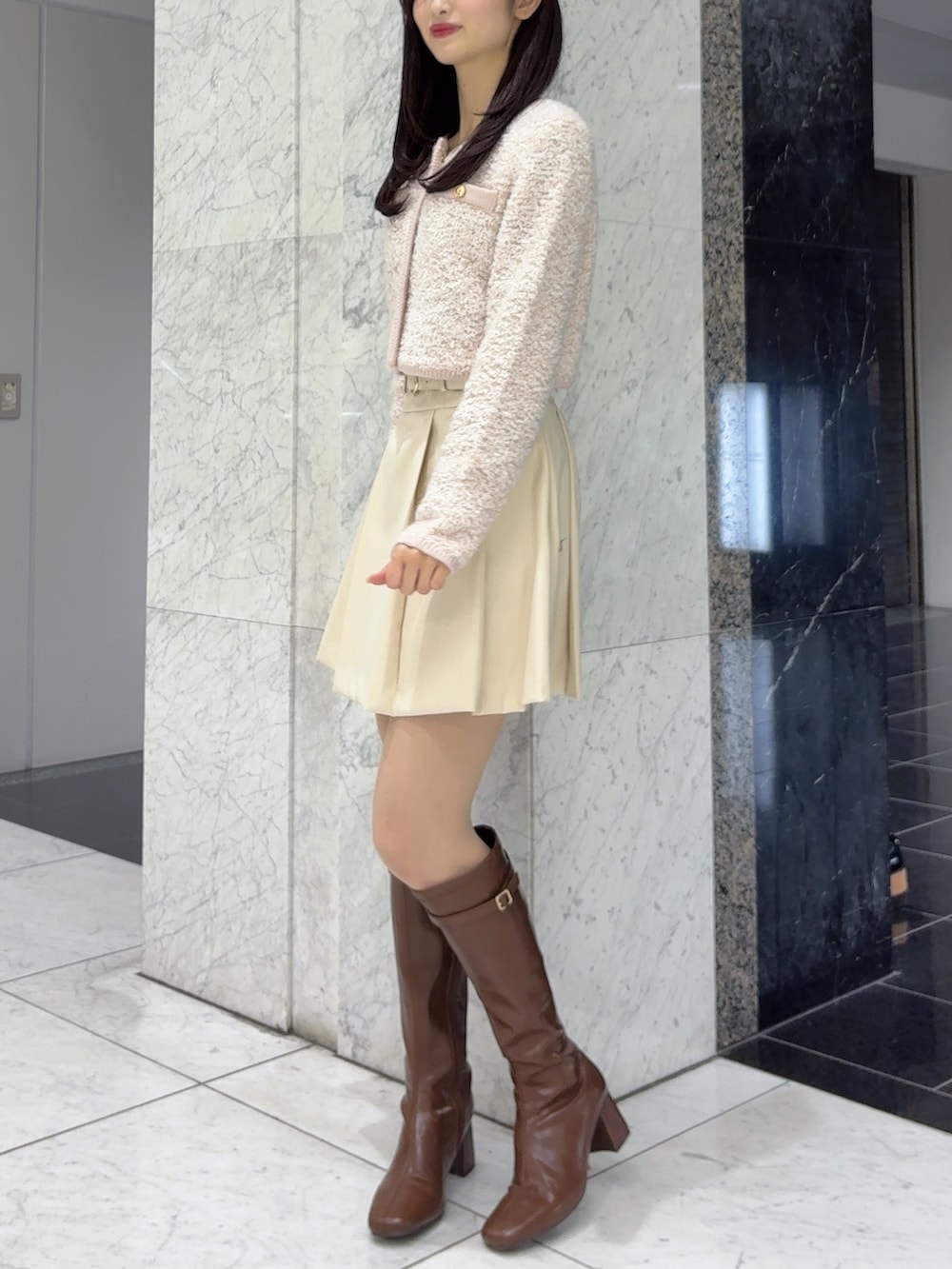 ホワイト系のスカート、ピンク系のノーカラージャケット、ブラウン系のブーツを着用したレディースの冬コーディネートの2枚目の写真