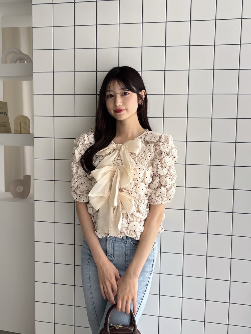 ブラウン系のハンドバッグ、ブルー系のデニムパンツ、ホワイト系のシャツ/ブラウスを着用したレディースの夏コーディネートの4枚目の写真