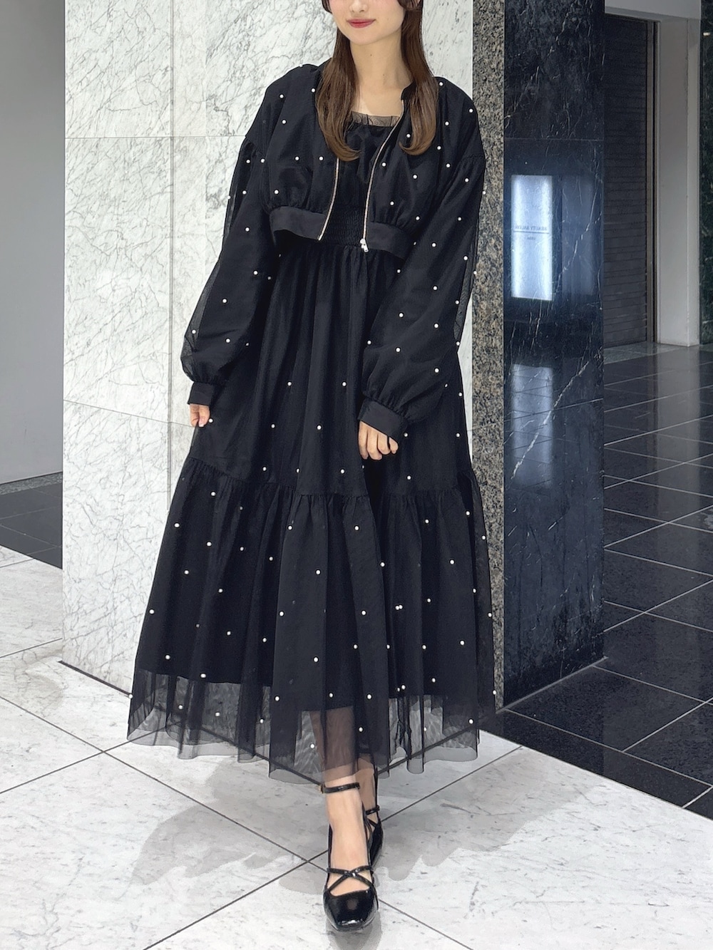 ブラック系のワンピース、ブラック系のブルゾン、ブラック系のサンダルを着用したレディースの春コーディネートの3枚目の写真