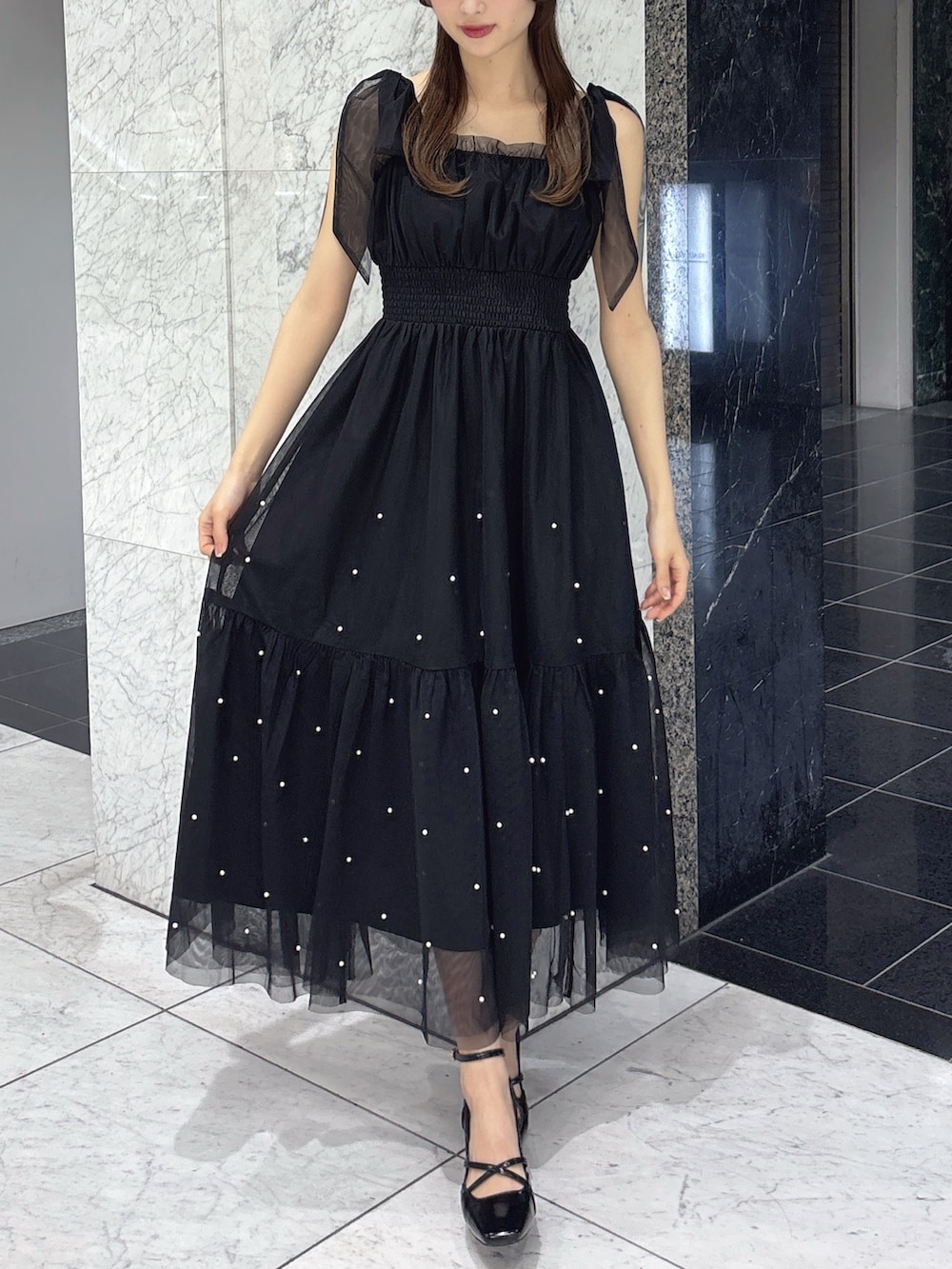 ブラック系のワンピース、ブラック系のブルゾン、ブラック系のサンダルを着用したレディースの春コーディネートの2枚目の写真