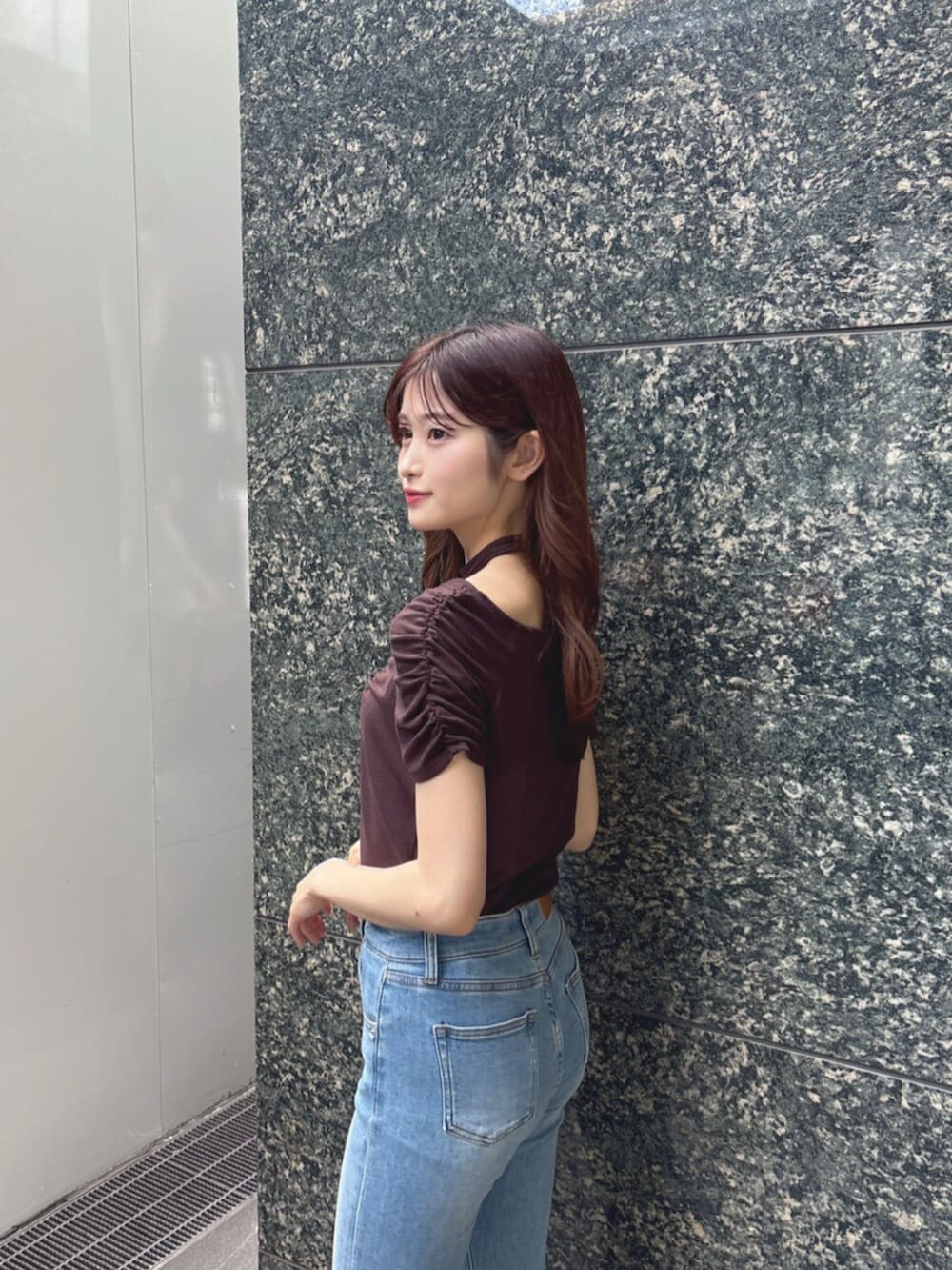 ブルー系のデニムパンツ、ブラウン系のTシャツ/カットソー、ブラウン系のサンダルを着用したレディースの春コーディネートの6枚目の写真