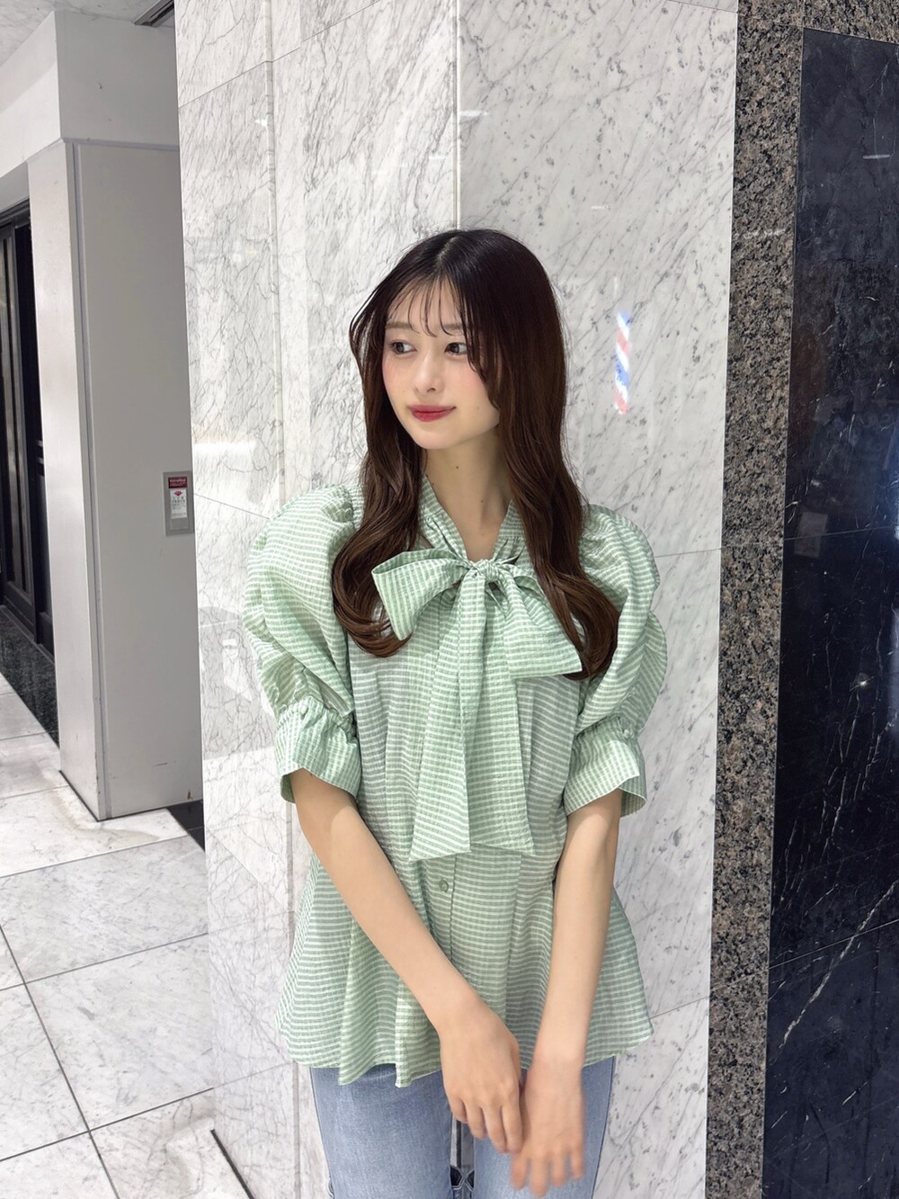 グリーン系のシャツ/ブラウス、ブルー系のデニムパンツ、ホワイト系のパンプスを着用したレディースの春コーディネートの4枚目の写真