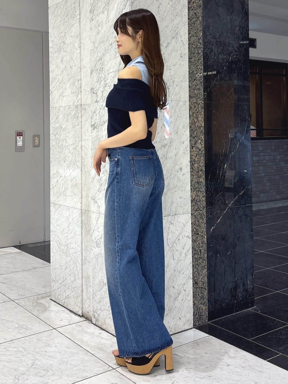ブルー系のニット/セーター、ブルー系のデニムパンツ、ホワイト系のサンダルを着用したレディースの春コーディネートの2枚目の写真