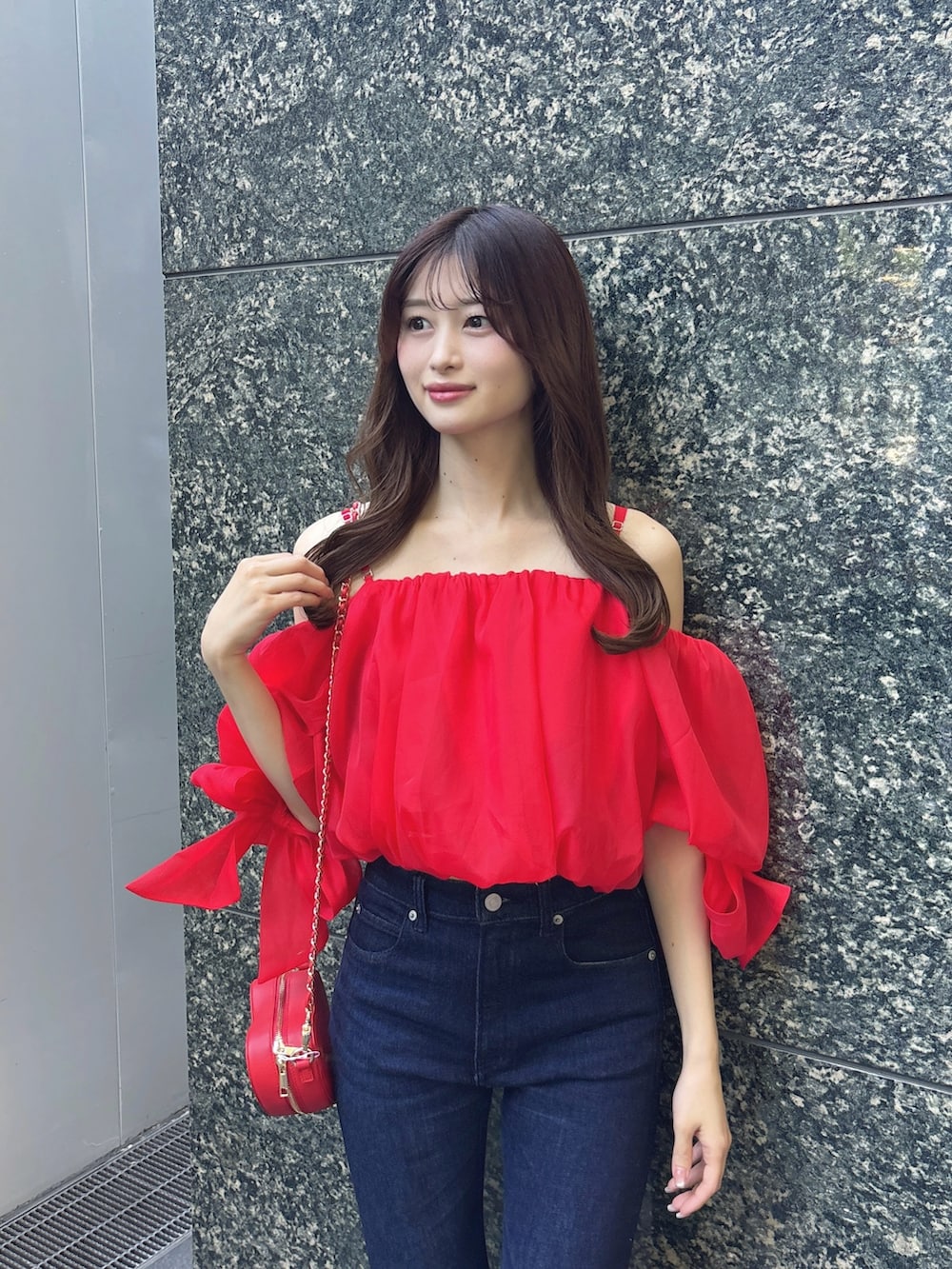 ブルー系のデニムパンツ、レッド系のシャツ/ブラウス、レッド系のショルダーバッグを着用したレディースの春コーディネートの5枚目の写真