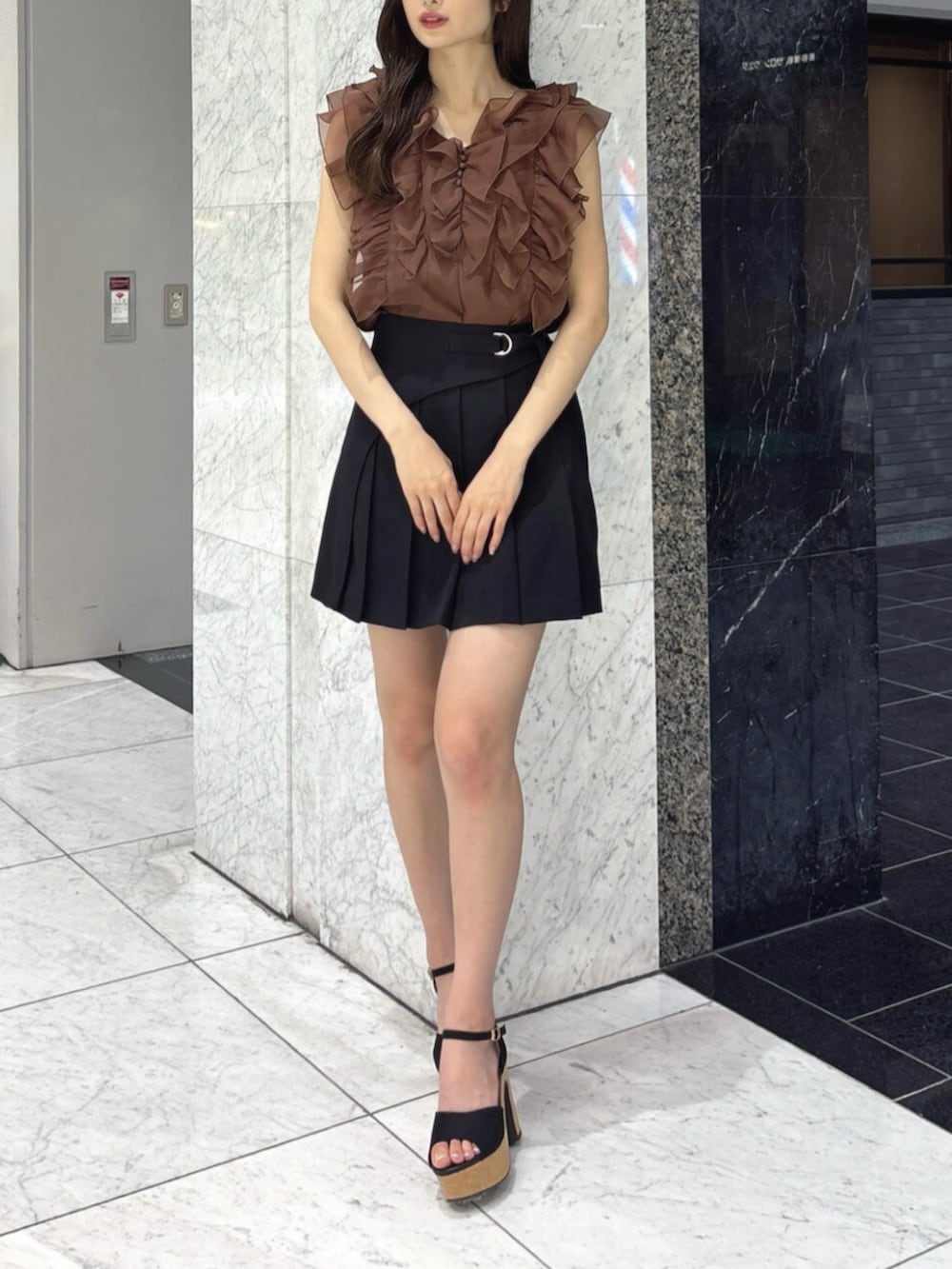 ブラック系のサンダル、ブラック系のスカート、ブラウン系のシャツ/ブラウスを着用したレディースの夏コーディネートの2枚目の写真