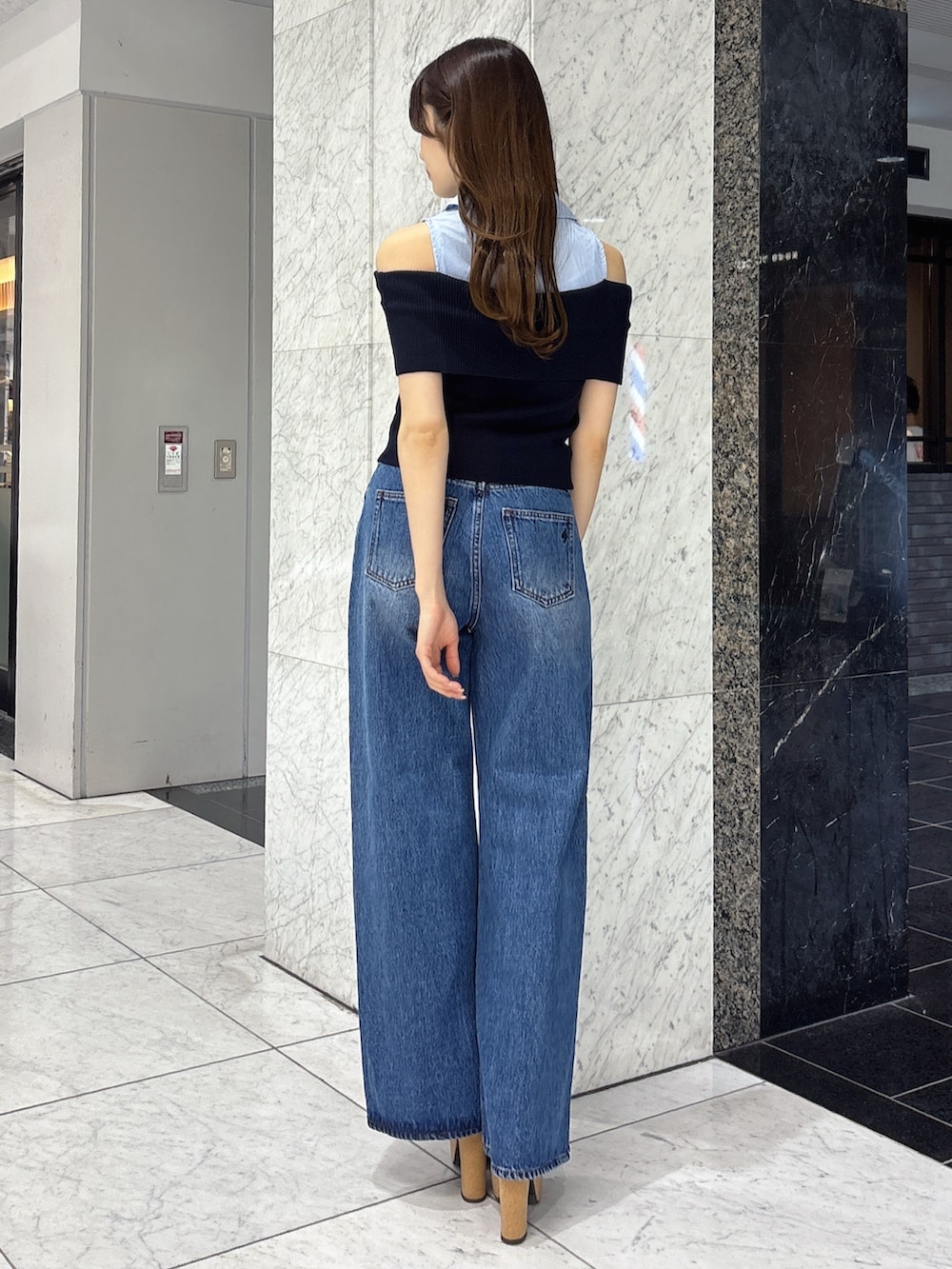 ブルー系のニット/セーター、ブルー系のデニムパンツ、ホワイト系のサンダルを着用したレディースの春コーディネートの3枚目の写真