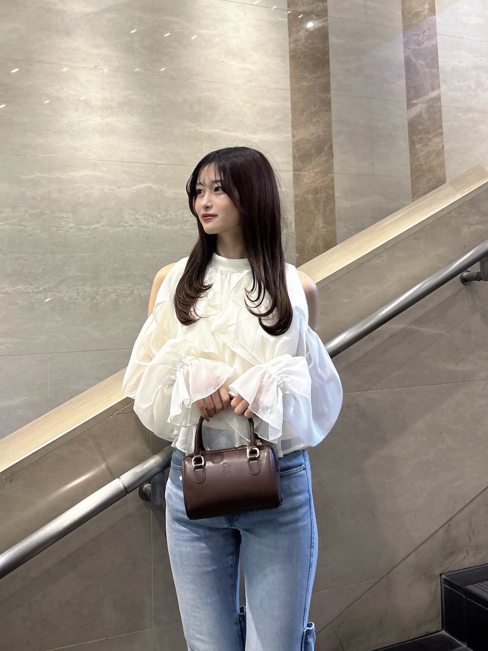 ブルー系のデニムパンツ、ホワイト系のシャツ/ブラウス、ホワイト系のパンプスを着用したレディースの春コーディネートの6枚目の写真