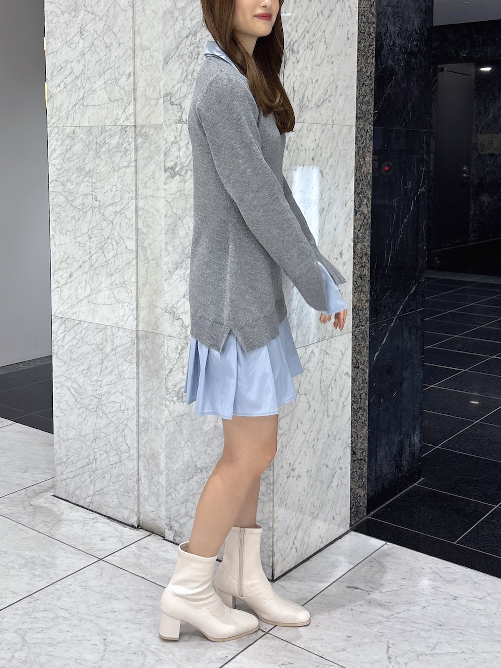 グレー系のワンピース、ホワイト系のブーツを着用したレディースの秋コーディネートの2枚目の写真