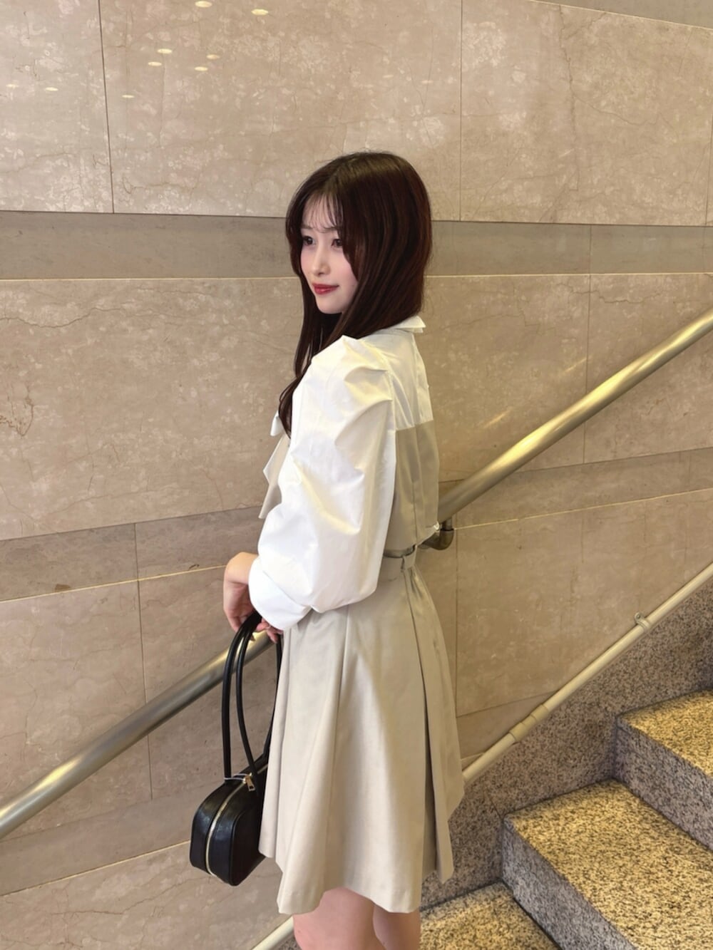 ベージュ系のワンピース、ブラック系のハンドバッグ、ブラック系のパンプスを着用したレディースの春コーディネートの6枚目の写真