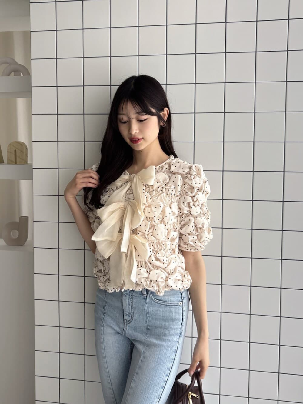 ブラウン系のハンドバッグ、ブルー系のデニムパンツ、ホワイト系のシャツ/ブラウスを着用したレディースの夏コーディネートの5枚目の写真
