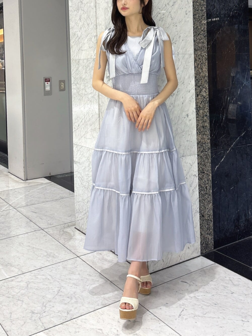 ホワイト系のサンダル、ブルー系のワンピースを着用したレディースの夏コーディネートの3枚目の写真