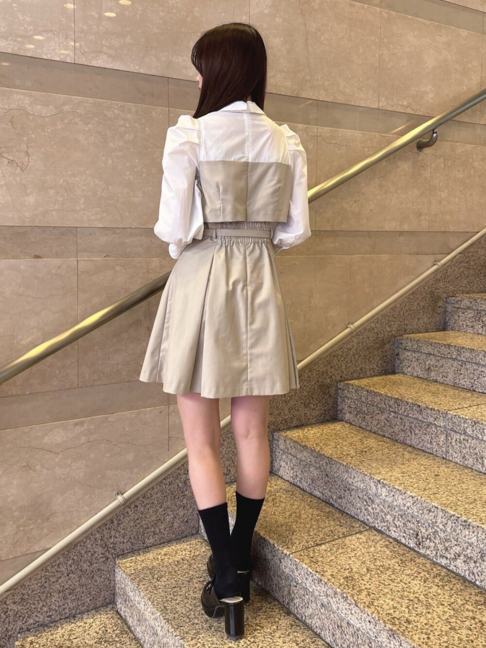 ベージュ系のワンピース、ブラック系のハンドバッグ、ブラック系のパンプスを着用したレディースの春コーディネートの4枚目の写真