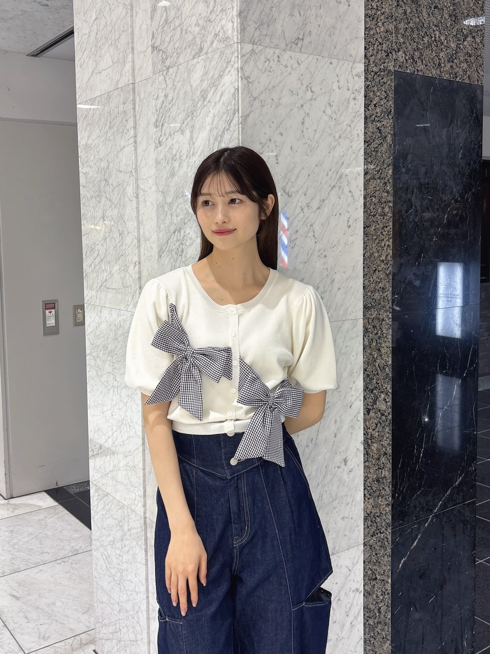 ブルー系のデニムパンツ、ホワイト系のサンダル、ホワイト系のニット/セーターを着用したレディースの春コーディネートの4枚目の写真