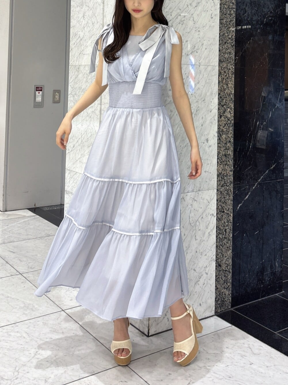 ホワイト系のサンダル、ブルー系のワンピースを着用したレディースの夏コーディネートの2枚目の写真