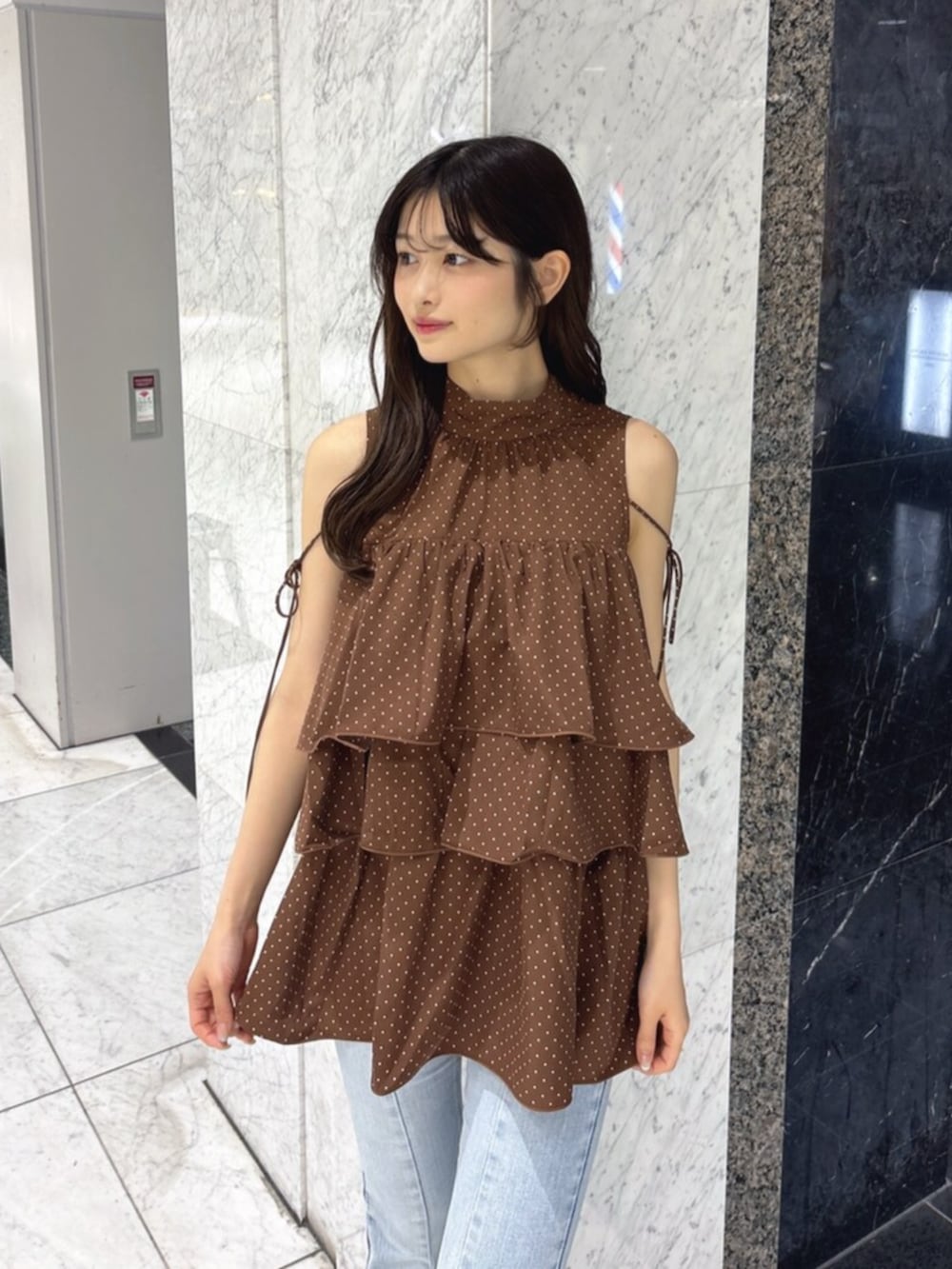 ホワイト系のサンダル、ブルー系のデニムパンツ、ブラウン系のかごバッグを着用したレディースの夏コーディネートの4枚目の写真