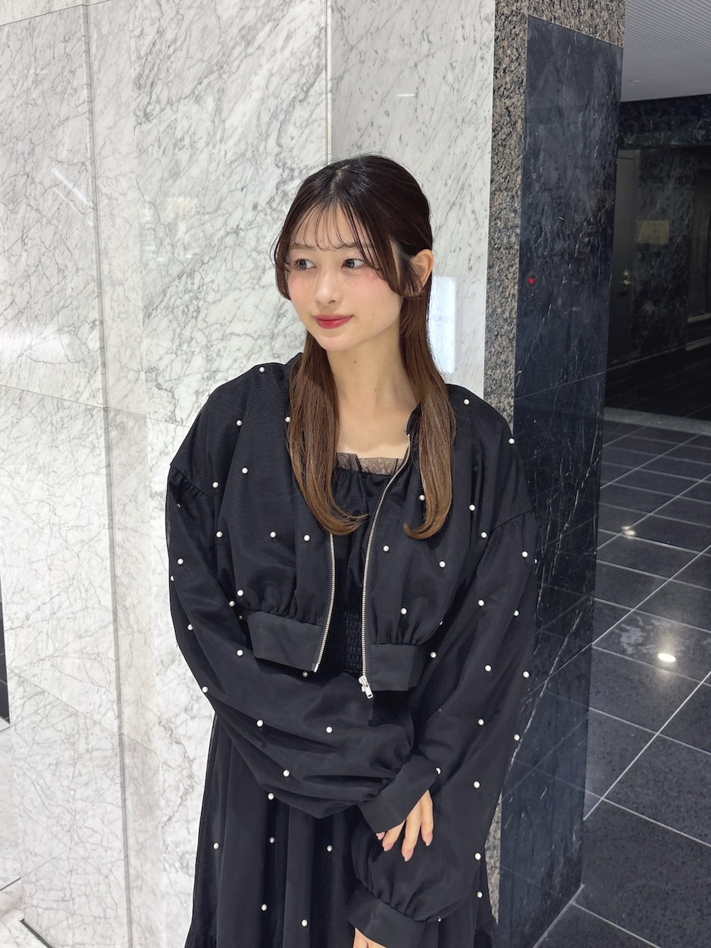 ブラック系のワンピース、ブラック系のブルゾン、ブラック系のサンダルを着用したレディースの春コーディネートの6枚目の写真