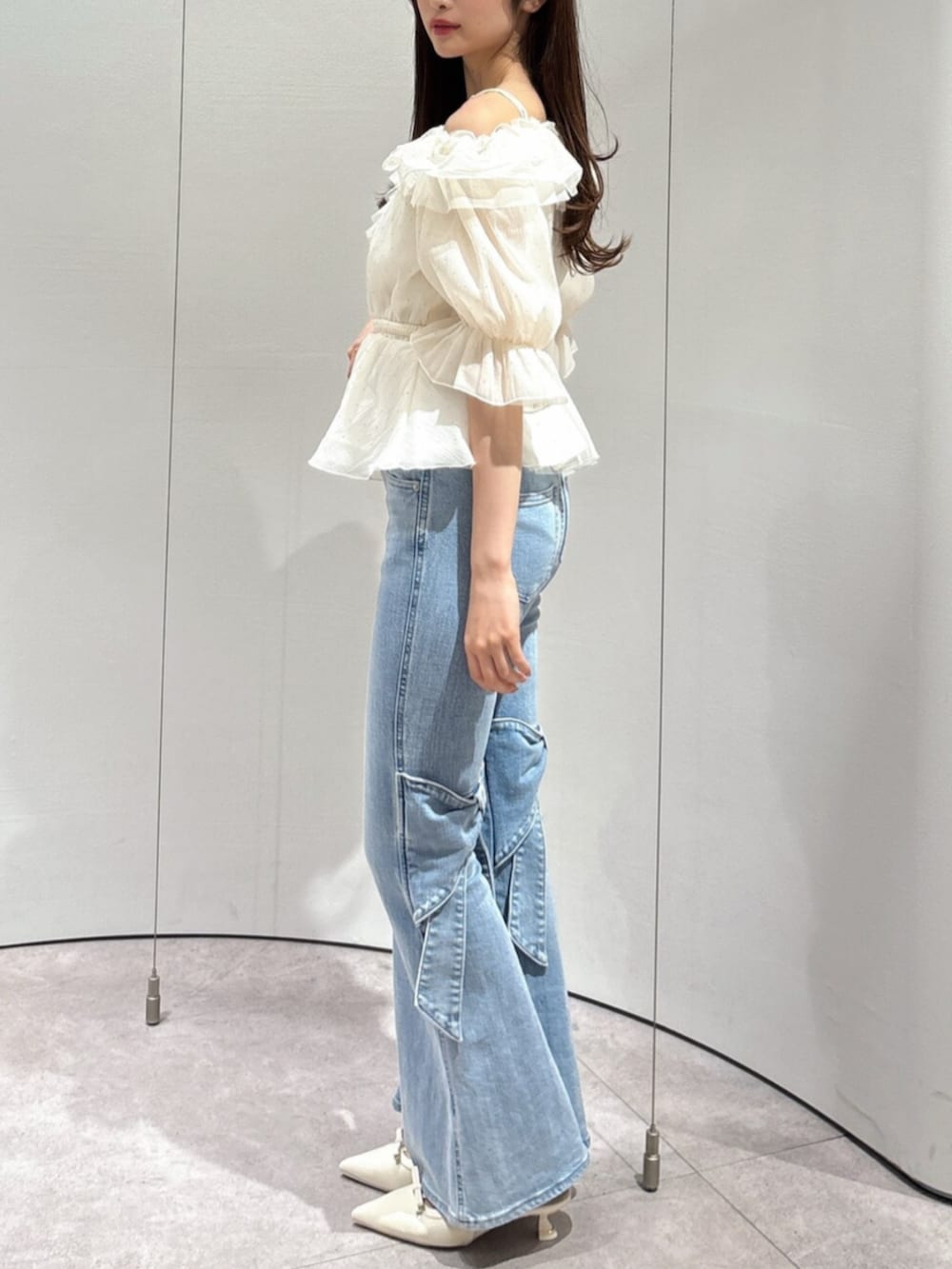 ブルー系のデニムパンツ、ホワイト系のパンプス、ホワイト系のシャツ/ブラウスを着用したレディースの春コーディネートの3枚目の写真
