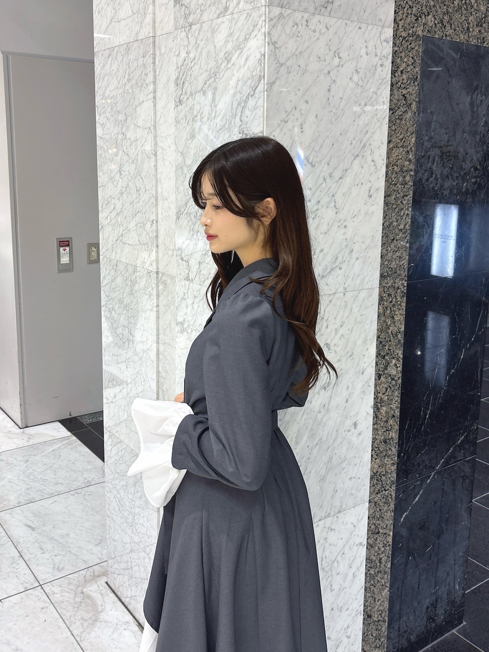 グレー系のワンピース、ブラック系のブーツを着用したレディースの秋コーディネートの7枚目の写真