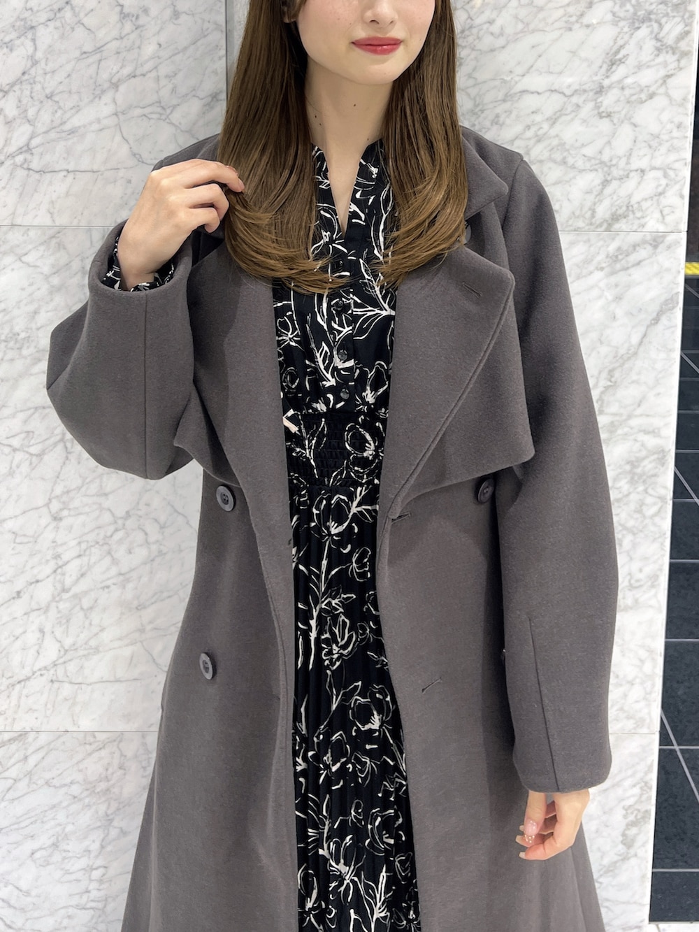 ブラック系のワンピース、ブラウン系のトレンチコート、ブラック系のブーツを着用したレディースの秋コーディネートの6枚目の写真