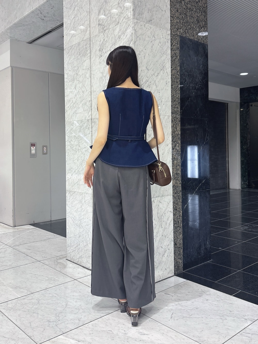 グレー系のその他パンツ、ブルー系のベスト、ブラウン系のサンダルを着用したレディースの夏コーディネートの3枚目の写真