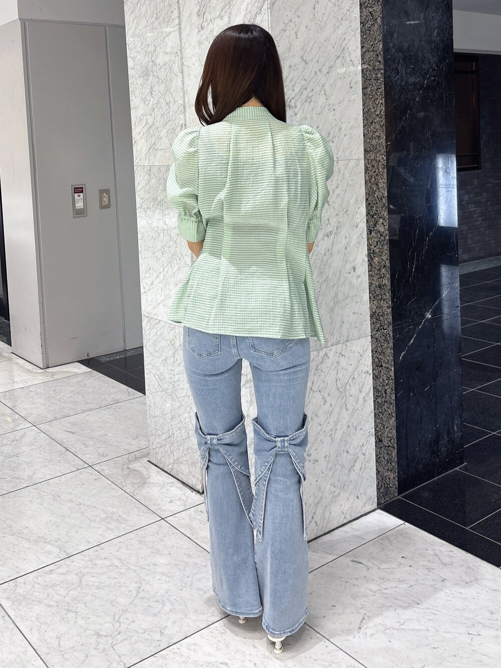 グリーン系のシャツ/ブラウス、ブルー系のデニムパンツ、ホワイト系のパンプスを着用したレディースの春コーディネートの3枚目の写真