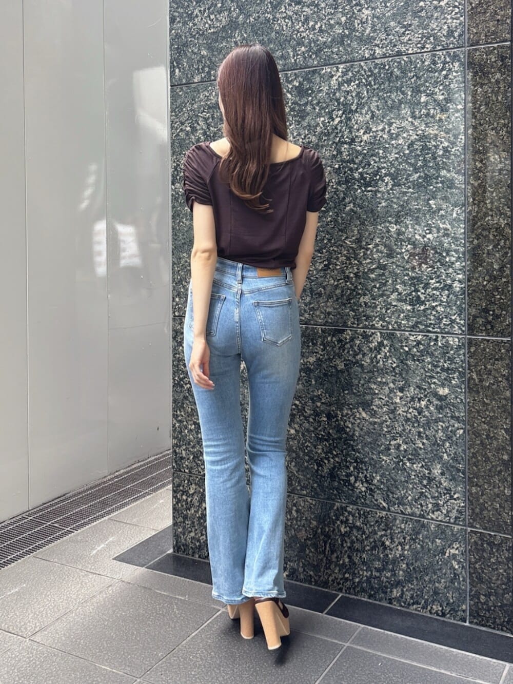 ブルー系のデニムパンツ、ブラウン系のTシャツ/カットソー、ブラウン系のサンダルを着用したレディースの春コーディネートの4枚目の写真