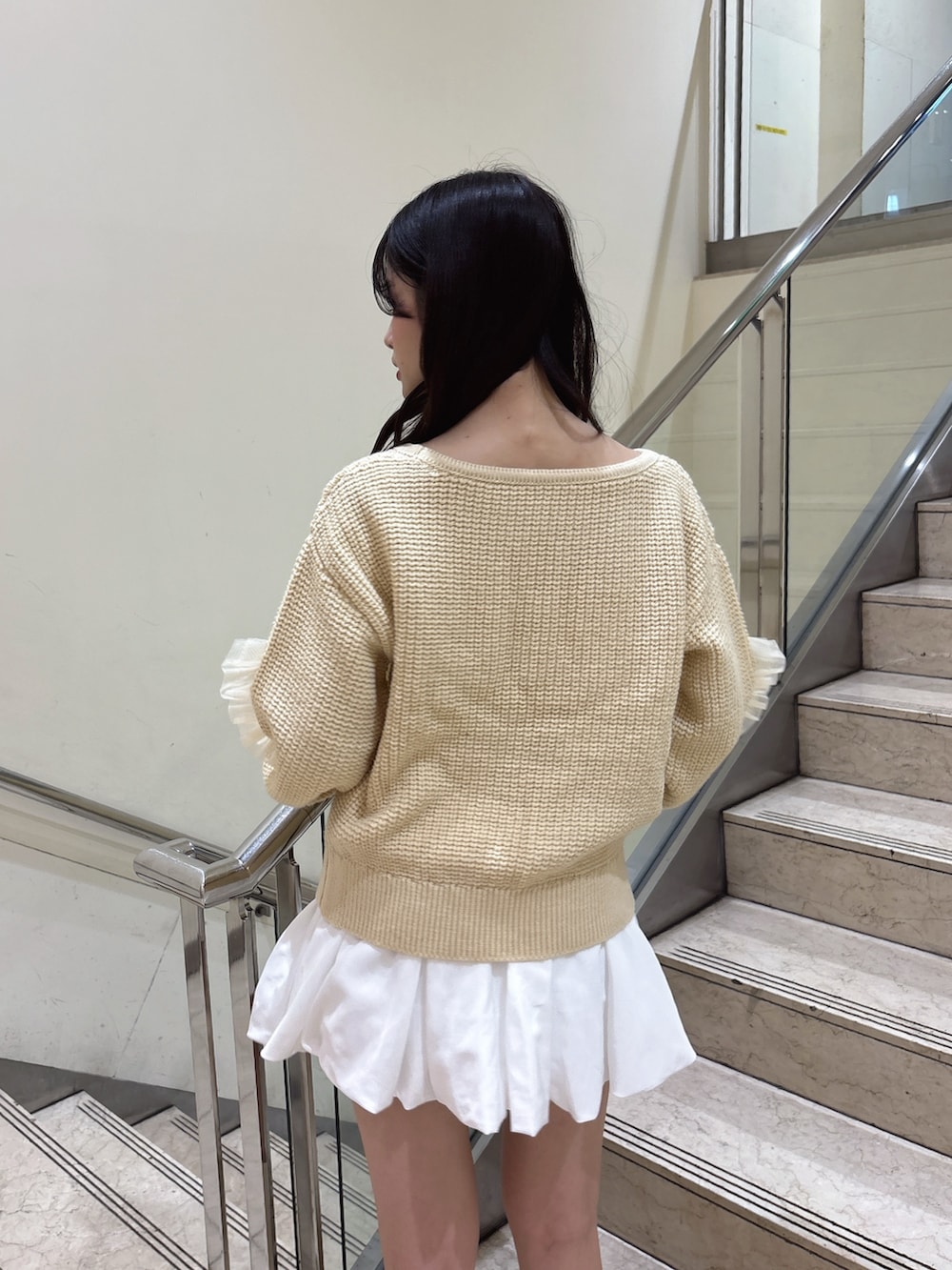 ホワイト系のスカート、ホワイト系のブーツ、イエロー系のハンドバッグを着用したレディースの秋コーディネートの6枚目の写真