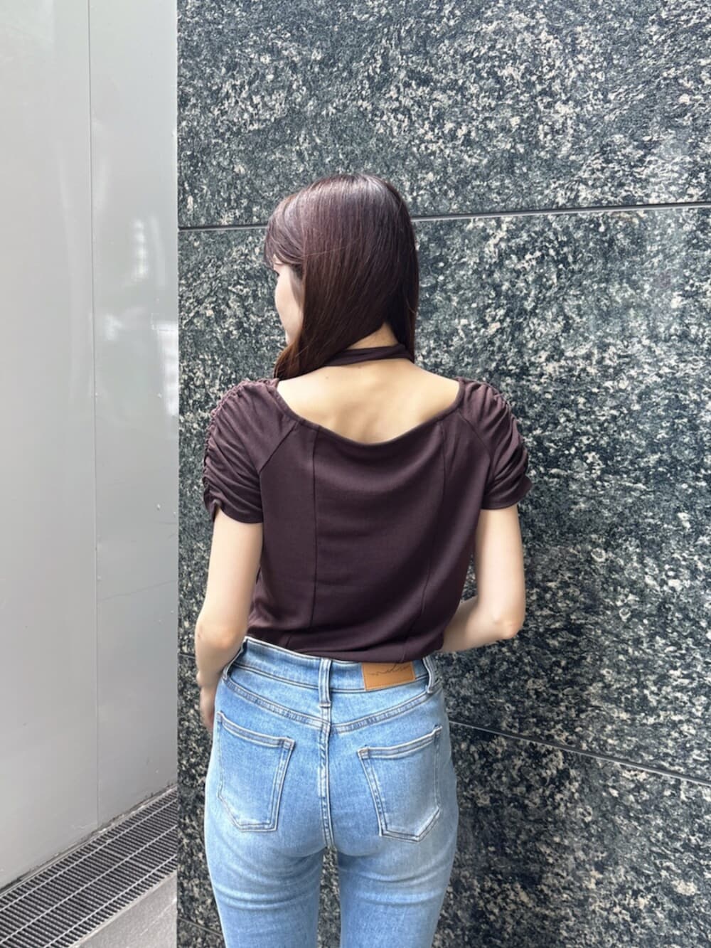 ブルー系のデニムパンツ、ブラウン系のTシャツ/カットソー、ブラウン系のサンダルを着用したレディースの春コーディネートの7枚目の写真