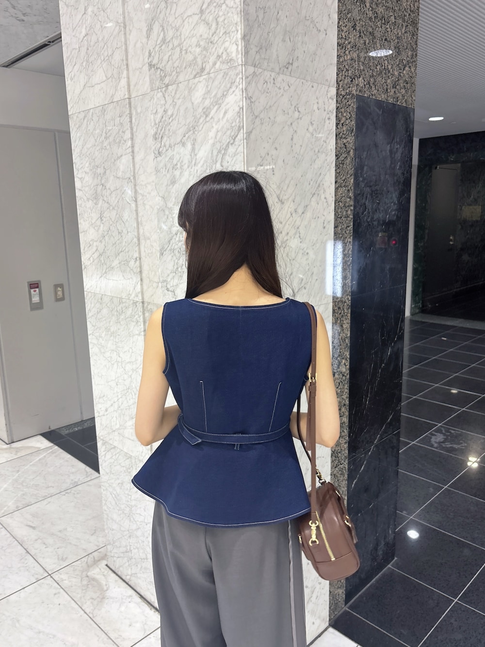 グレー系のその他パンツ、ブルー系のベスト、ブラウン系のサンダルを着用したレディースの夏コーディネートの5枚目の写真