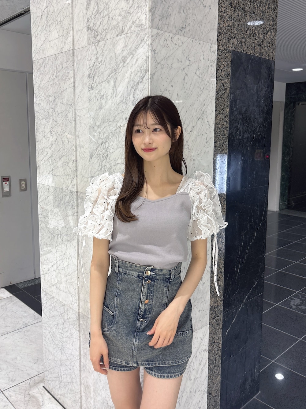 ブルー系のデニムパンツ、グレー系のTシャツ/カットソー、ホワイト系のサンダルを着用したレディースの春コーディネートの5枚目の写真
