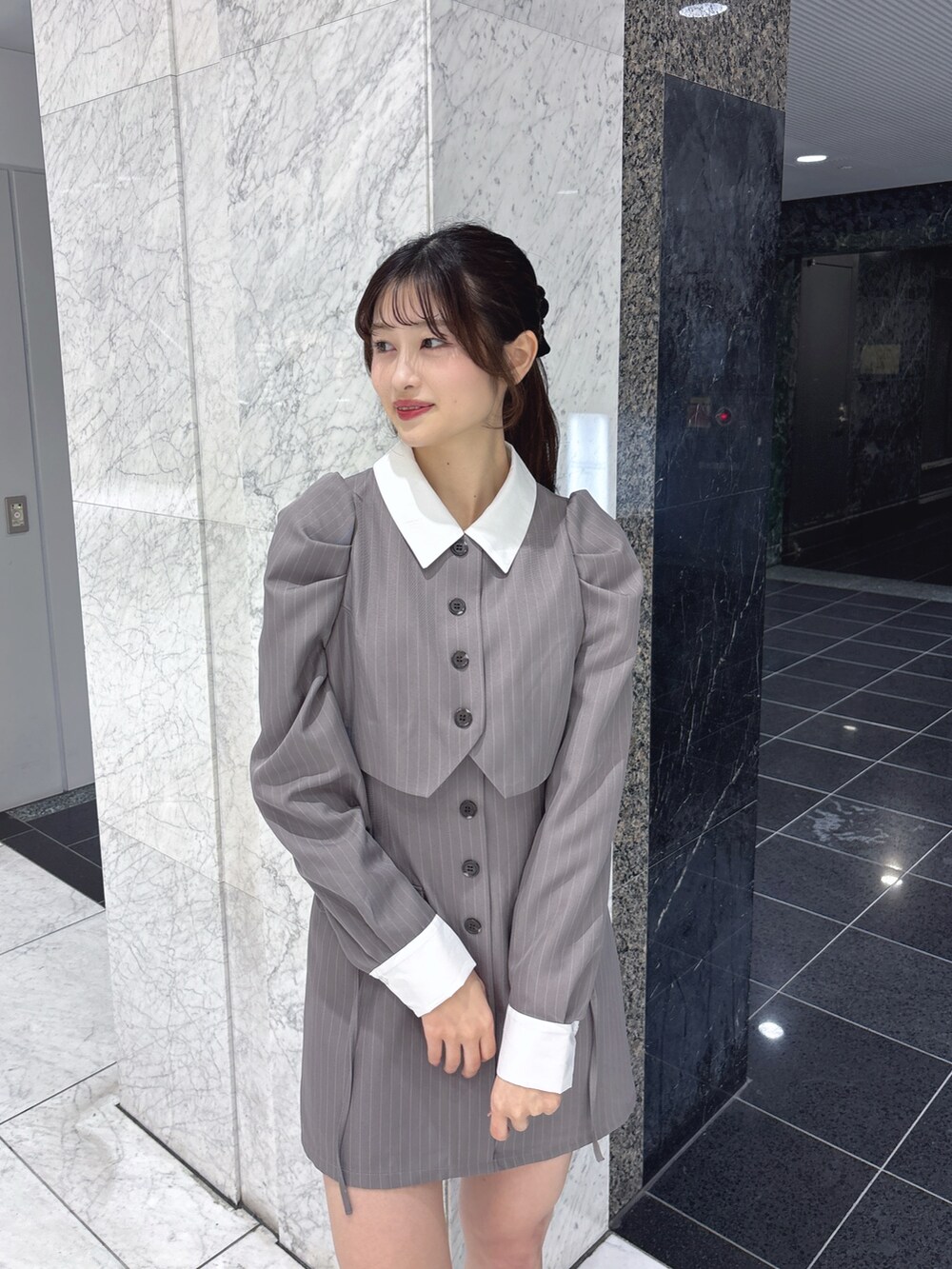 グレー系のワンピース、ブラック系のサンダルを着用したレディースの冬コーディネートの6枚目の写真