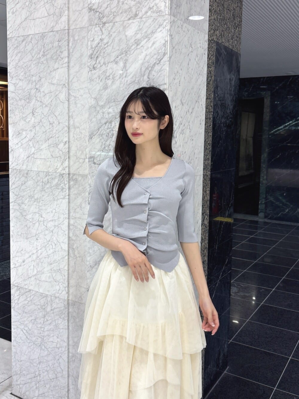 ホワイト系のスカート、グレー系のニット/セーター、ホワイト系のパンプスを着用したレディースの夏コーディネートの5枚目の写真
