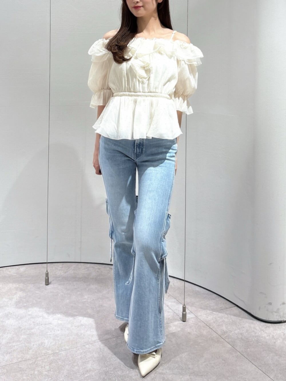 ブルー系のデニムパンツ、ホワイト系のパンプス、ホワイト系のシャツ/ブラウスを着用したレディースの春コーディネートの2枚目の写真