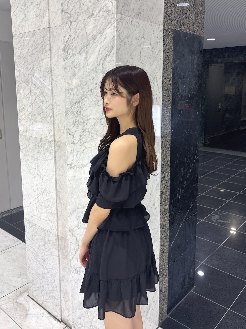 ブラック系のスカート、ブラック系のシャツ/ブラウス、ブラック系のサンダルを着用したレディースの春コーディネートの6枚目の写真