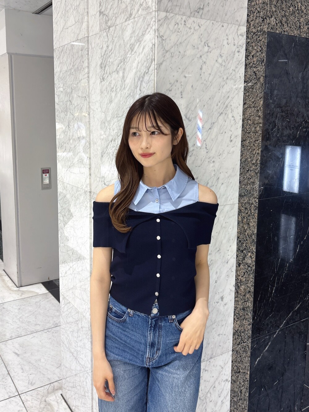 ブルー系のニット/セーター、ブルー系のデニムパンツ、ホワイト系のサンダルを着用したレディースの春コーディネートの5枚目の写真