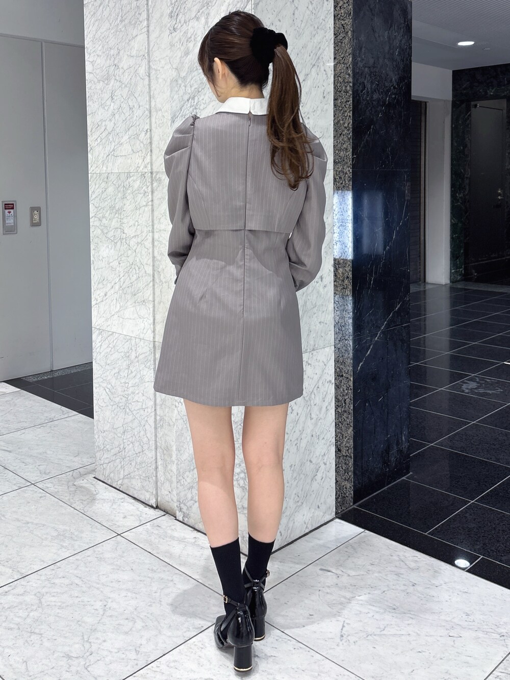 グレー系のワンピース、ブラック系のサンダルを着用したレディースの冬コーディネートの4枚目の写真